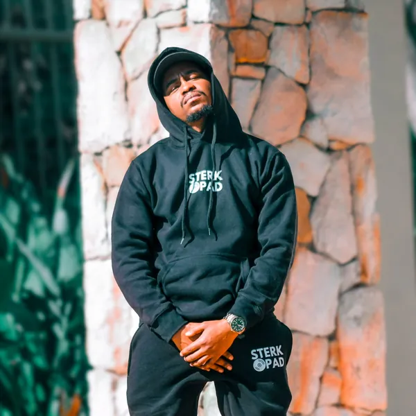 Eazy OGee in a SterkOpad tracksuit against a stone wall