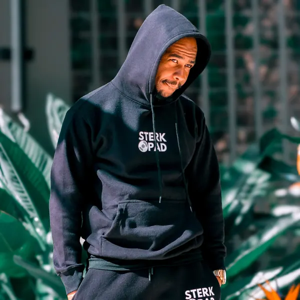 SterkOpad artist in a branded hoodie surrounded by greenery