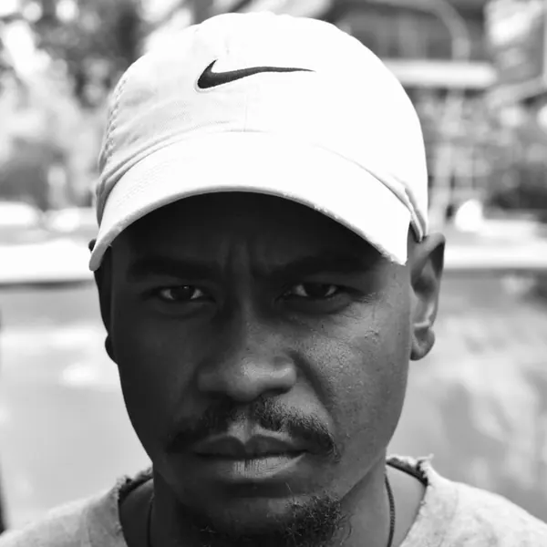 Black and white portrait of a SterkOpad artist in a Nike cap
