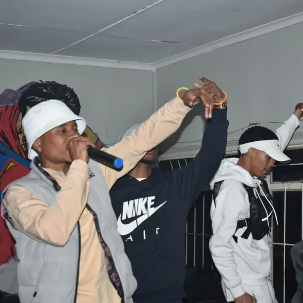 SterkOpad artists performing indoors with the crowd's hands up