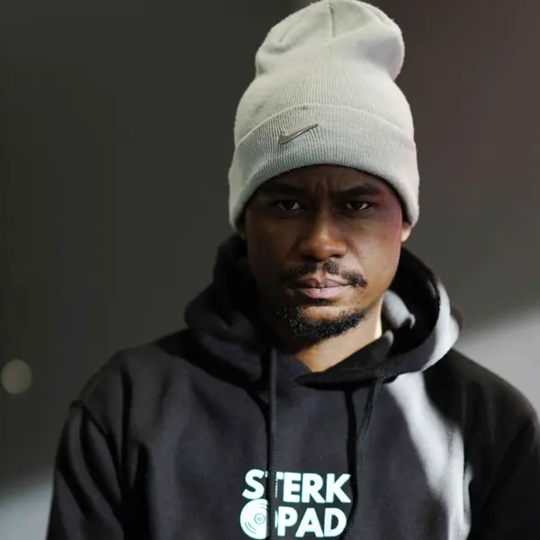 SterkOpad artist in a branded hoodie against a grey studio wall