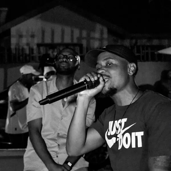 Black and white shot of an artist on the mic in a crowd