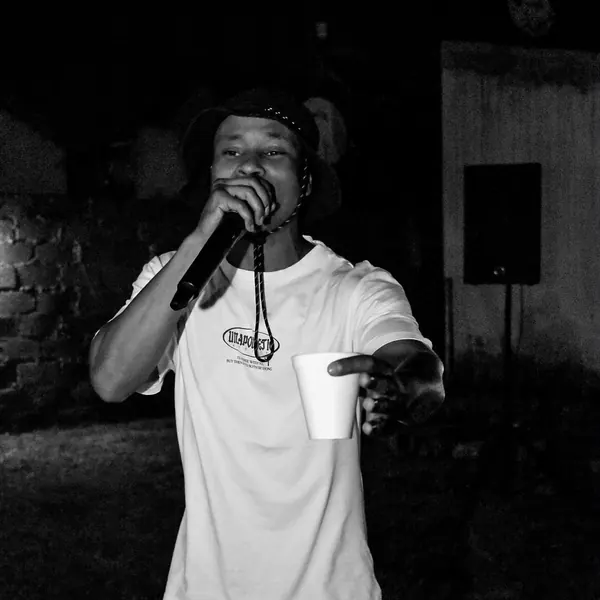Black and white shot of an artist on the mic holding a cup