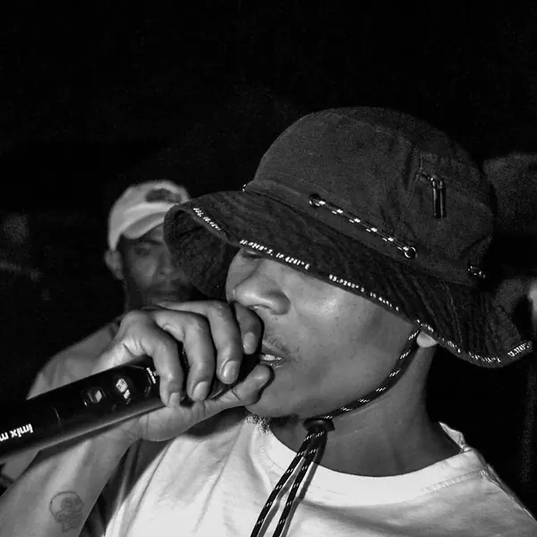 Black and white shot of an artist in a bucket hat on the mic