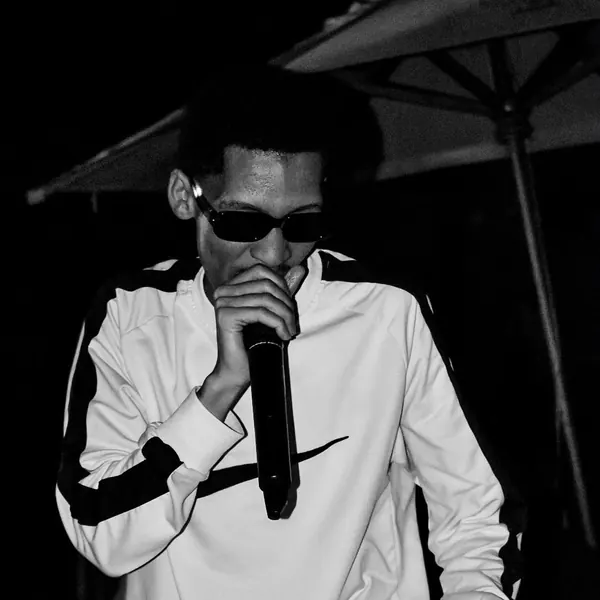 Black and white shot of an artist in sunglasses on the mic