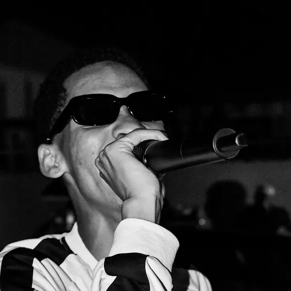 Close black and white shot of an artist on the mic