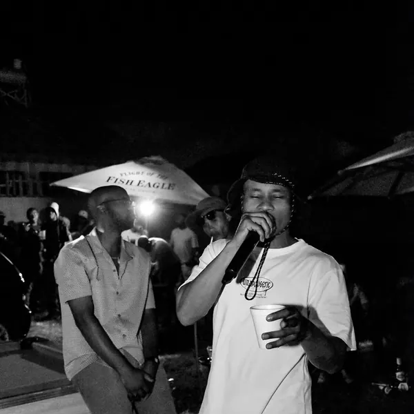 Two artists performing together under an umbrella at night